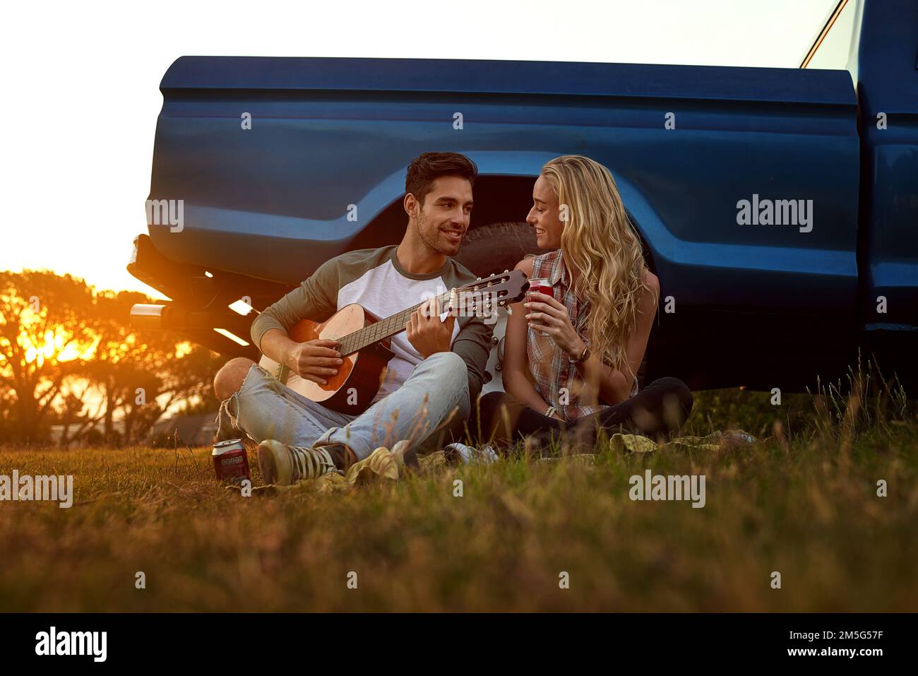 Lieder von Liebe und Romantik. Ein junger Mann, der Gitarre für seine Freundin spielt. Stockfoto