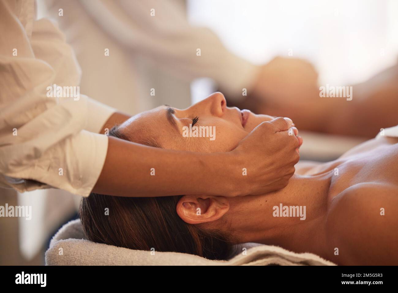 Frauenmassage mit Therapeuten-Händen, Gesichtspflege und reiki, Ruhe und Balance mit kosmetischem Luxus-Service im Wellnesscenter. Hautpflege, Schönheit und Selbstpflege Stockfoto