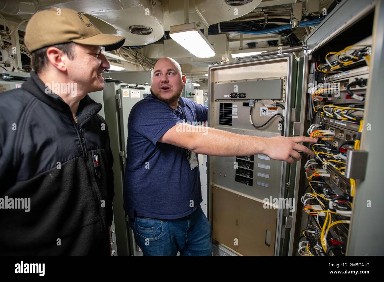 Feuerwehrmann Petty Officer 2. Klasse Luke Wheeler, Left, und Ship Self-Defense System in-Service Engineering Agent Adam Troczynski arbeiten im Combat Information Center Unbeaufsichtigter Ausrüstungsraum während einer Combat Systems Assessment Team Veranstaltung an Bord der USS Anchorage (LPD 23), März 16 im Naval Surface Warfare Center, Port Hueneme Division. Stockfoto