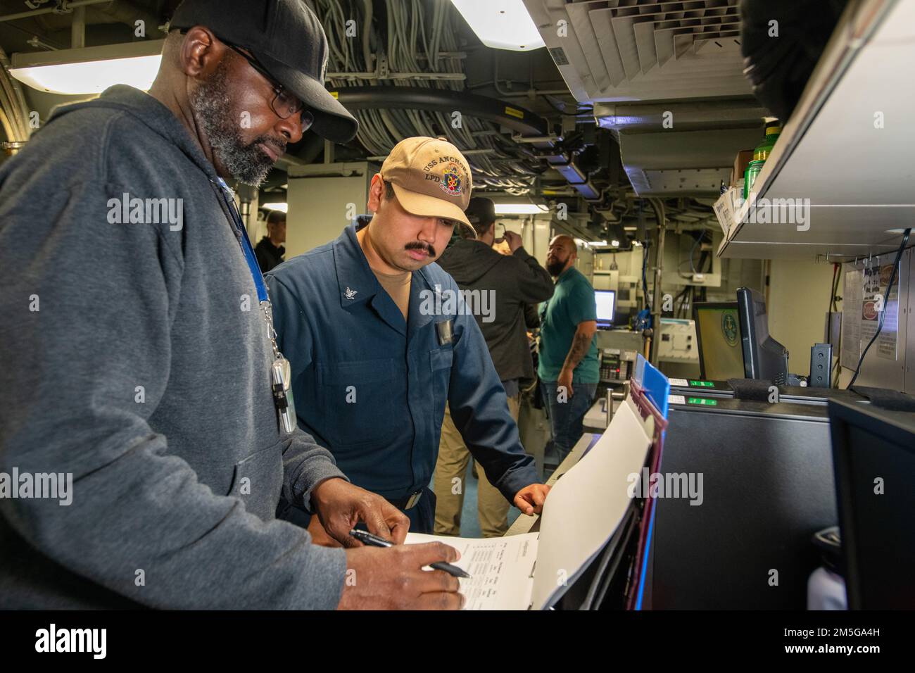 Von links arbeitet das Wartungsteam Logistiker Ronald Billups mit Petty Officer 3. Class Gabriel Soto zusammen, um die Validierung der Wartungsanforderungskarten in einem der Radarräume an Bord der USS Anchorage (LPD 23) durchzuführen, während sie im Hafen des Naval Surface Warfare Center, Port Hueneme Division, Für Combat Systems Assessment und Training am 16. März. Stockfoto