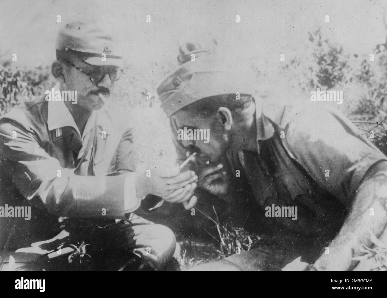 Birma-Kampagne, 1944-1945. Ein japanischer Offizier teilt sich eine Zigarette mit einem Soldaten der pro-japanischen Indischen Nationalarmee während einer kurzen Pause in ihrem letzten unglücklichen Vormarsch nach Indien, April 1944. Stockfoto