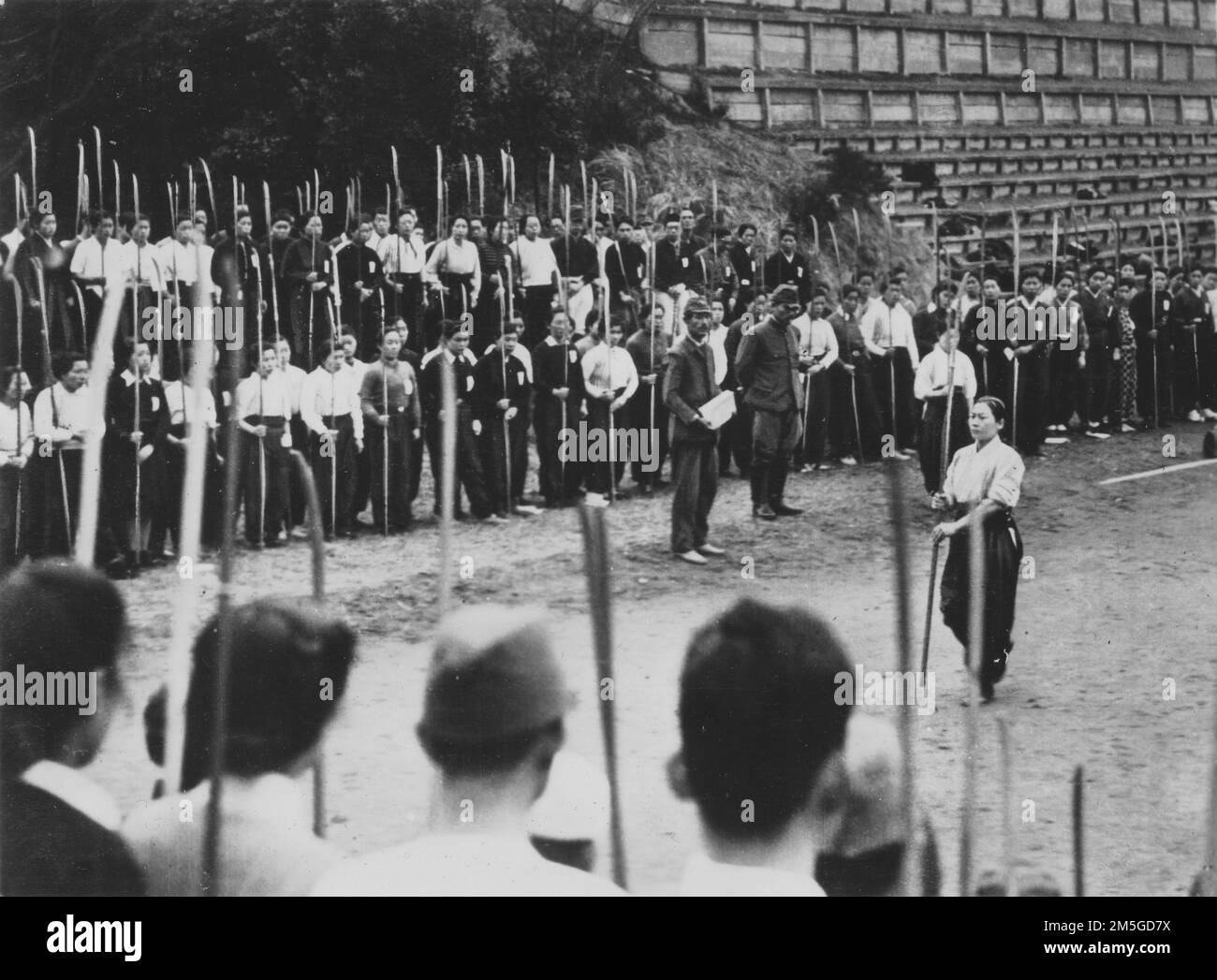 Pazifikkrieg, 1941-1945. Japanische Heimatfront - Japanerinnen der Mittelschule werden mit Naginata trainiert, da die Bedrohung durch eine Invasion der Alliierten auf den japanischen Heimatinseln näher rückt, März 1944. Stockfoto