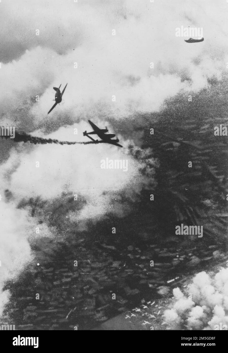 Pazifikkrieg, 1941-1945. Ein alliiertes P-38-Kampfflugzeug hinterlässt eine Rauchspur, wenn es direkt nach seiner Niederlage gegen Kampfflugzeuge der kaiserlichen Japanischen Armee über einem alliierten Flugplatz in Neuguinea am 1943. Dezember auf den Boden absteigt. Stockfoto