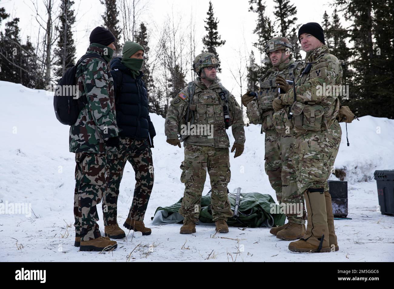 Von links nach rechts: Nepalesischer Militärmajor Maniraj Ghimire, Major Moahn Chettri Basnet, USA Kommandoleiter der Armee, Major Bryan O'Neal, Kommandoleiter, Major Dennis Doyle und Oberstleutnant John Westbrook diskutieren während des Joint Pacific Multiational Readiness Center 22-02 bei Ft. Greely, Alaska, 17. März 2022. Gemeinsam mit unseren Alliierten und Partnern verfeinern und setzen wir eine dauerhafte Wettbewerbsstrategie um, die die Erweiterung und Stärkung unseres regionalen Zugangs und Einflusses in der Arktis umfasst. Stockfoto