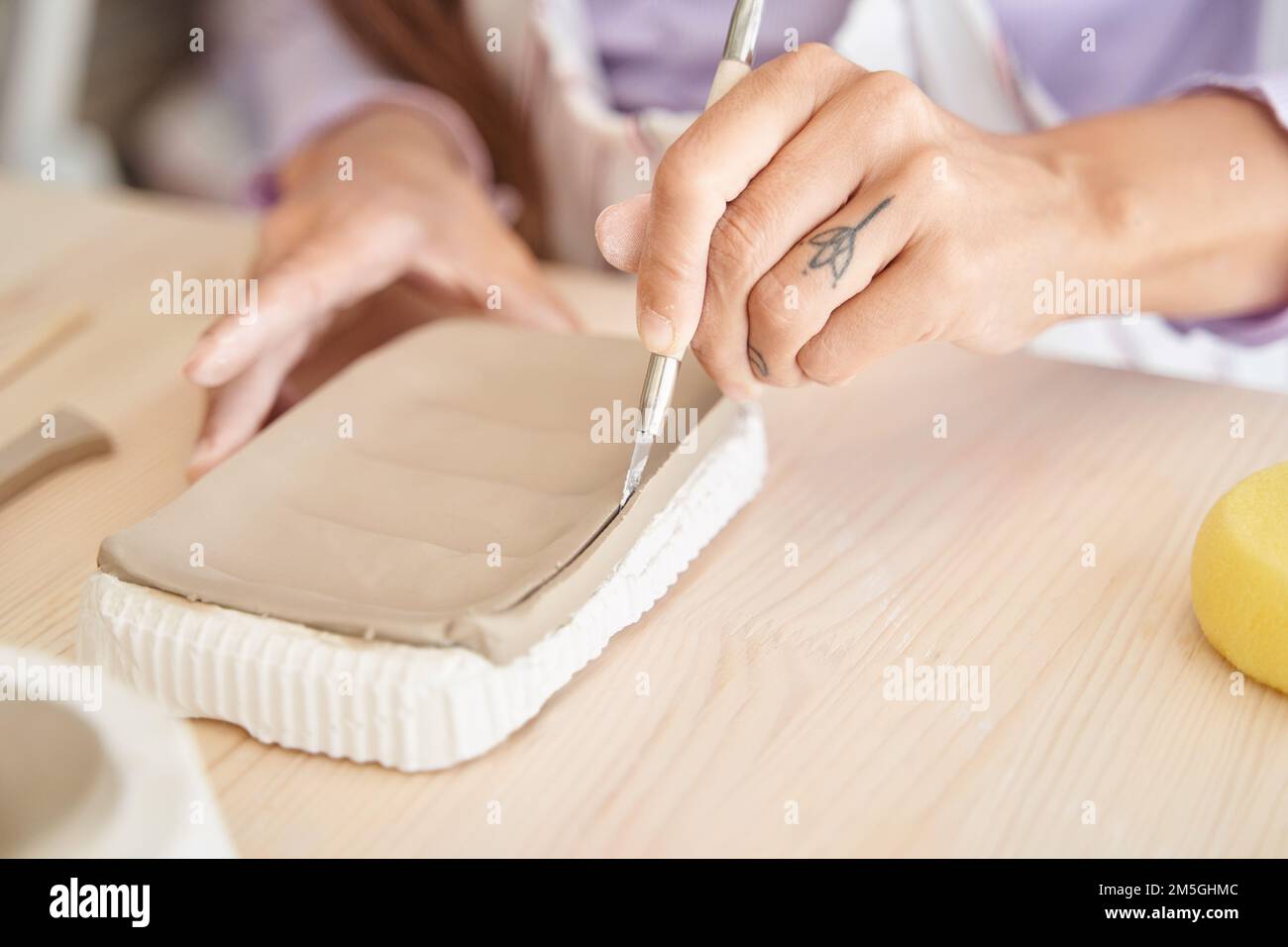 Nahaufnahme einer Frau, die mit Lehm in einer Töpferwerkstatt arbeitet. Handwerk und Hobbys. Stockfoto