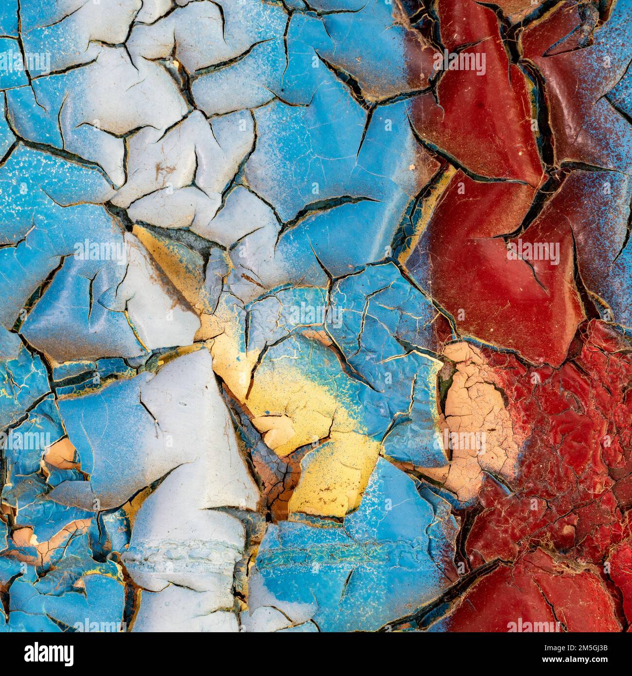 Rot, weiß und blau ablösende Farbe an einer alten Wand Stockfoto