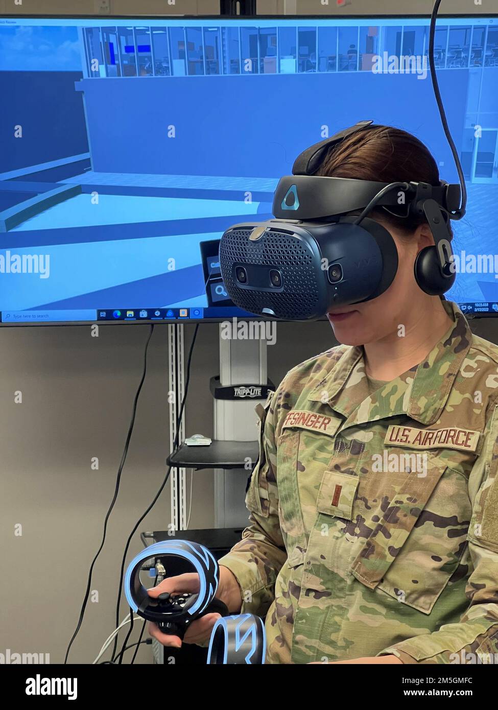 LT. Jackie Noffsinger verwendet zwei Handheld-Controller, die auf einer Gaming-System-Engine basieren, um durch den Digital Twin zu navigieren. Das Hololab dient als Tor zum digitalen Zwilling – einer virtuellen Welt, die geschaffen wurde, um Wartung, Modellierung und Simulation für die Installation der Zukunft zu verbessern. (Air Force Foto von David Ford) Stockfoto