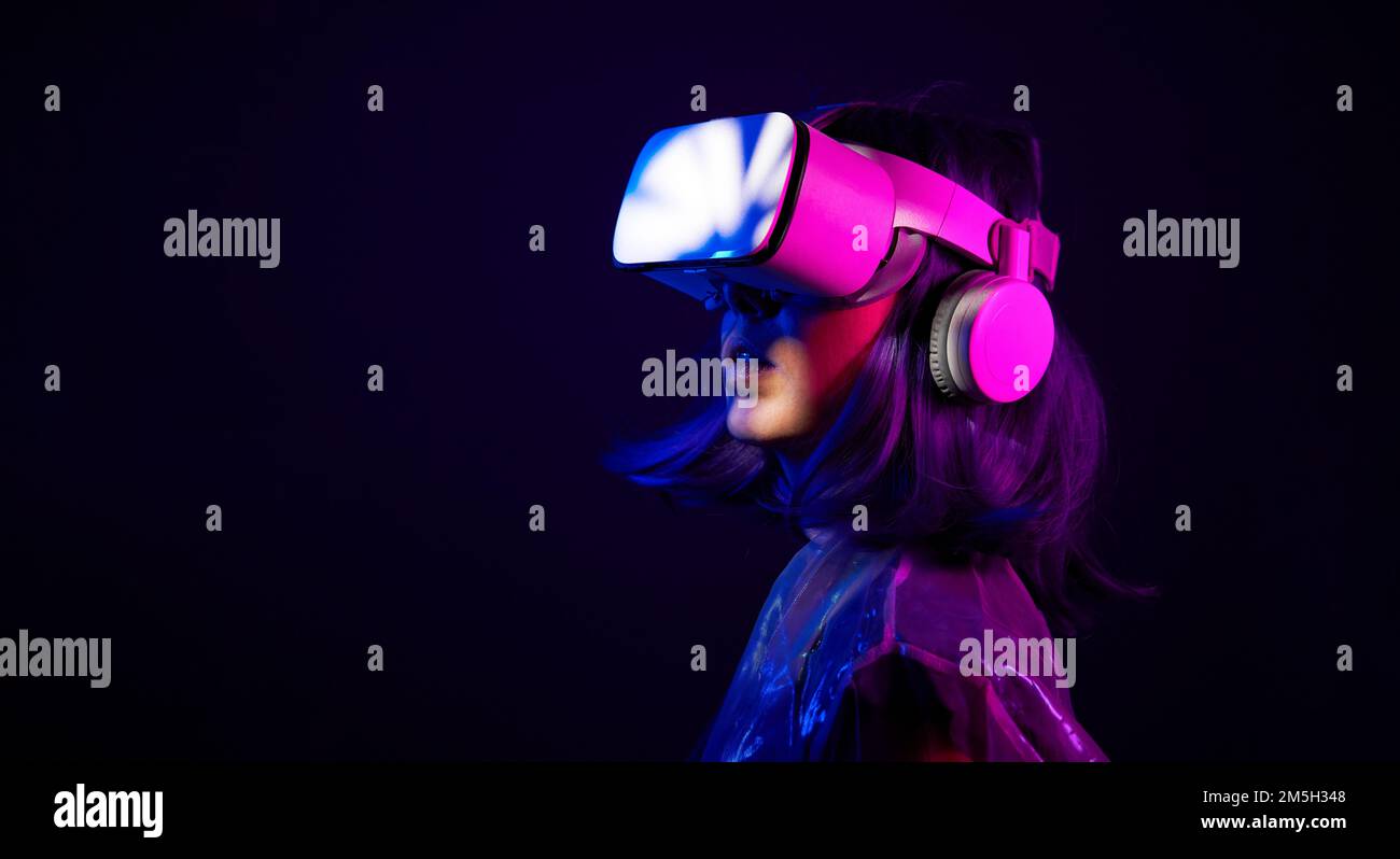 Eine Frau in Virtual-Reality-Brille in Neonfarben. Das Konzept der digitalen Technologie für Metaversum und Unterhaltung der Zukunft. Stockfoto