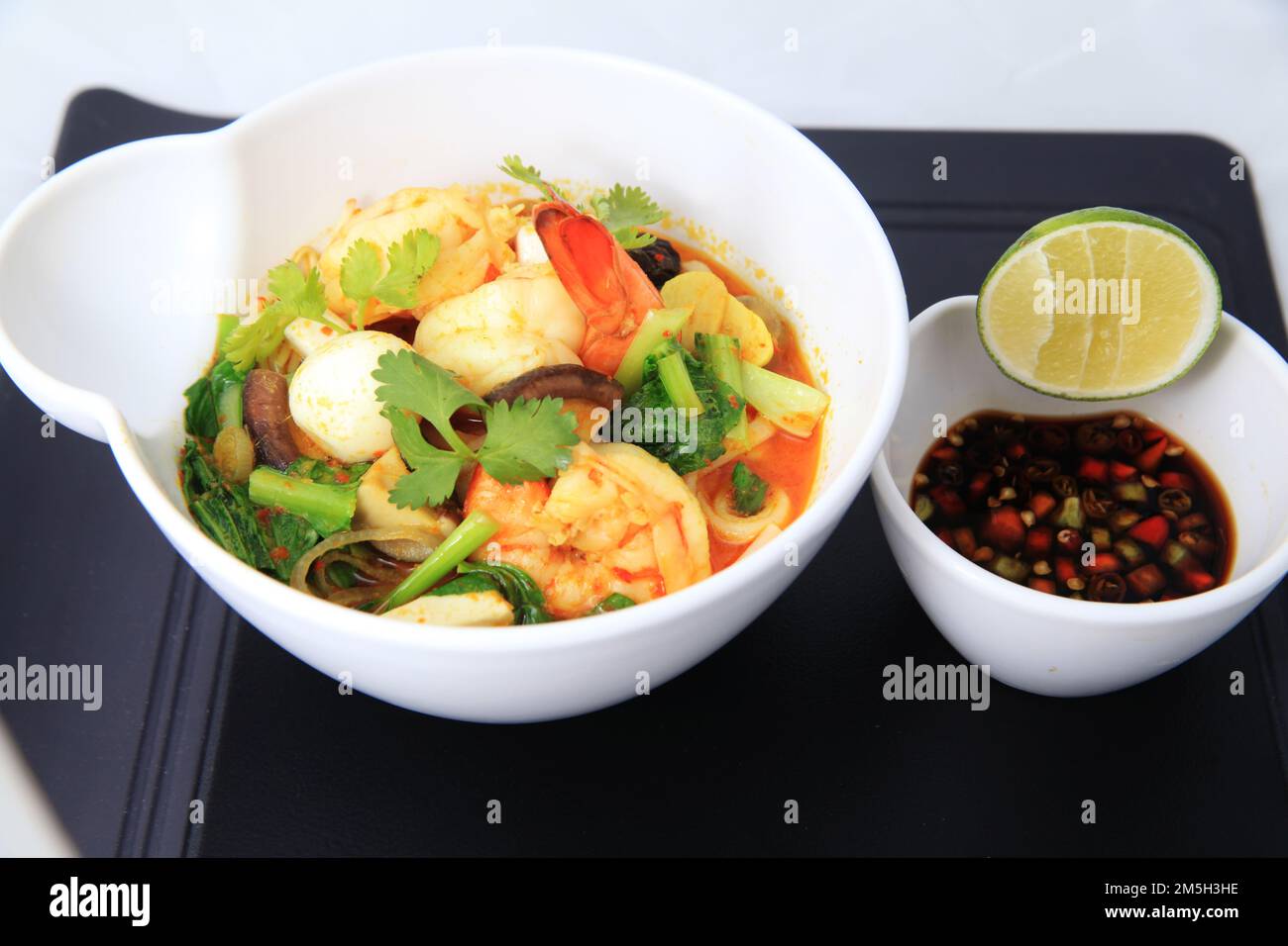 cinese Seafood Shrimp Curry Portion in der Schüssel, serviert mit Wachtelei Gemüse Limette Chili in Sojasoße Stockfoto