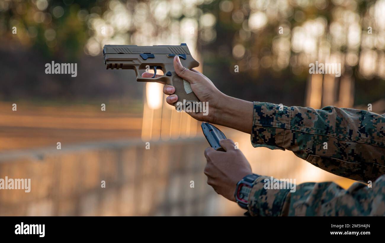 USA Axel CruzRamirez, Verwaltungsspezialist der Marine Corps Air Station New River, lädt die Sig Sauer M18 während einer Runde Übungsübungen im Rahmen des Marksmanship Competition in Stone Bay im Marine Corps Base Camp Lejeune, North Carolina, am 17. März 2022 neu. Der Marinekorps Marksmanship Competition fördert den Zusammenhalt der Einheit und die Einsatzbereitschaft, indem es Marines ermöglicht wird, mit Gewehren und Pistolen zu konkurrieren und die Letalität zu verbessern. Stockfoto