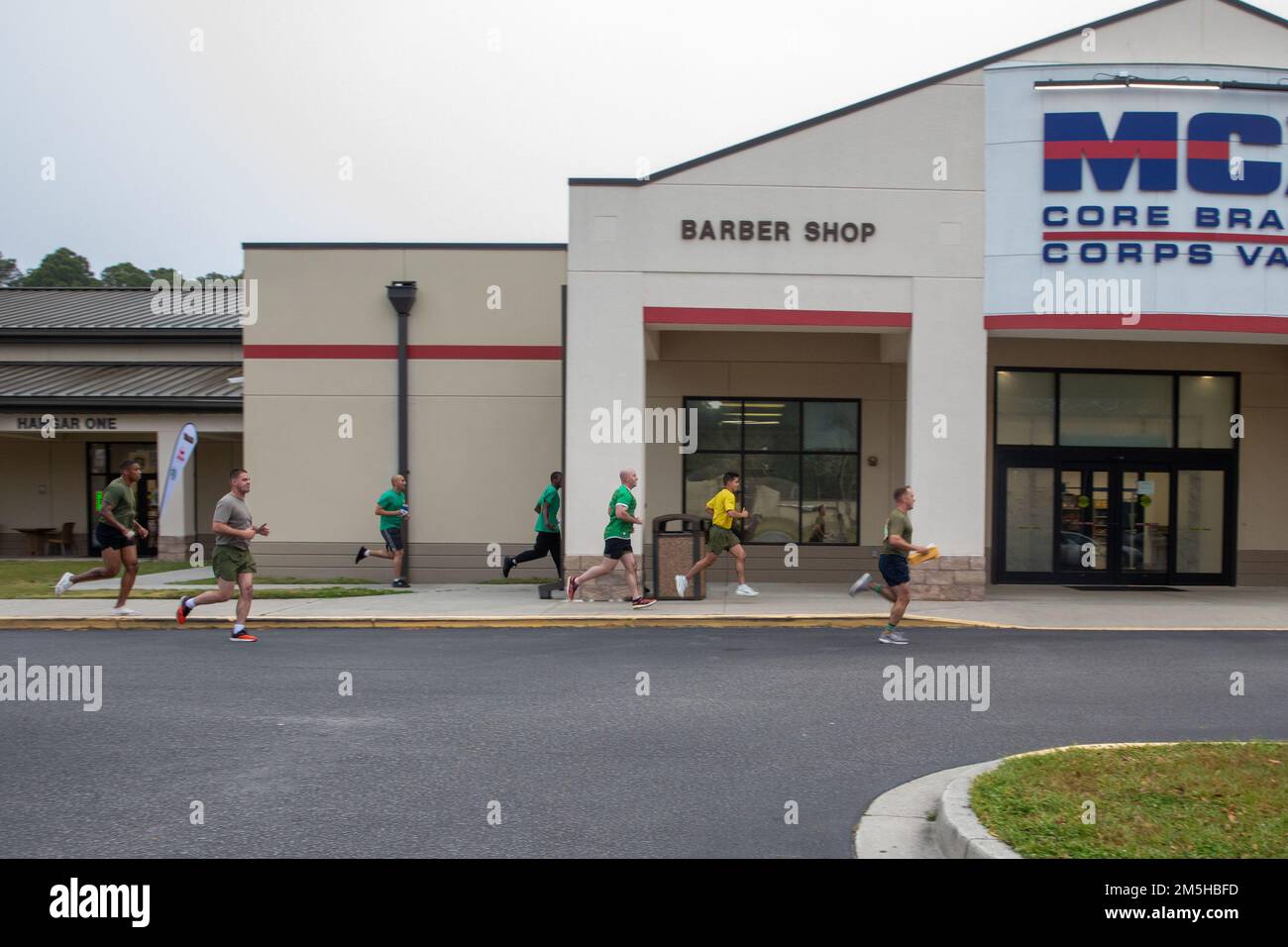 USA Marines und Matrosen mit der Marine Aircraft Group 31 und Headquarters and Headquarters Squadron, Marine Corps Air Station (MCAS) Beaufort, laufen an der Marine Corps Exchange vorbei während der St. Patrick's Day Amazing Race in MCAS Beaufort, South Carolina, 17. März 2022. Das Rennen brachte Marines und Matrosen zusammen, um einen freundschaftlichen Wettbewerb zu bieten und die Marines und Matrosen über die verfügbaren Ressourcen der Anlage zu informieren. Stockfoto