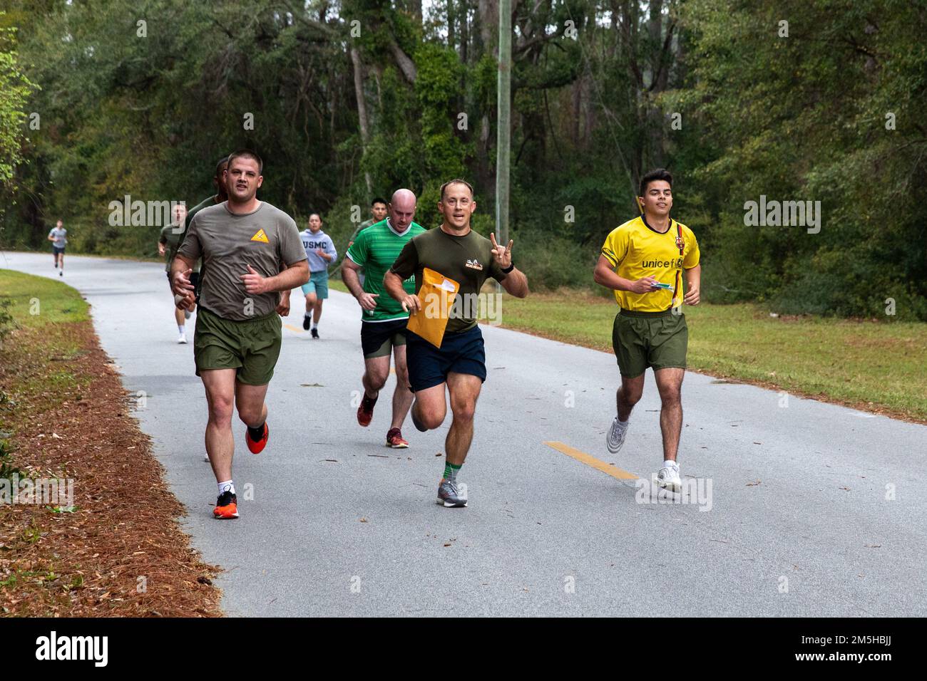 USA Marines und Matrosen mit der Marine Aircraft Group 31 und Headquarters and Headquarters Squadron, Marine Corps Air Station (MCAS) Beaufort, laufen auf die Ziellinie während der St. Patrick's Day Amazing Race in MCAS Beaufort, South Carolina, 17. März 2022. Den Marines wurde Frühstück für ihre Teilnahme am Rennen angeboten, und die drei besten Teams erhielten Auszeichnungen für ihre harte Arbeit. Stockfoto