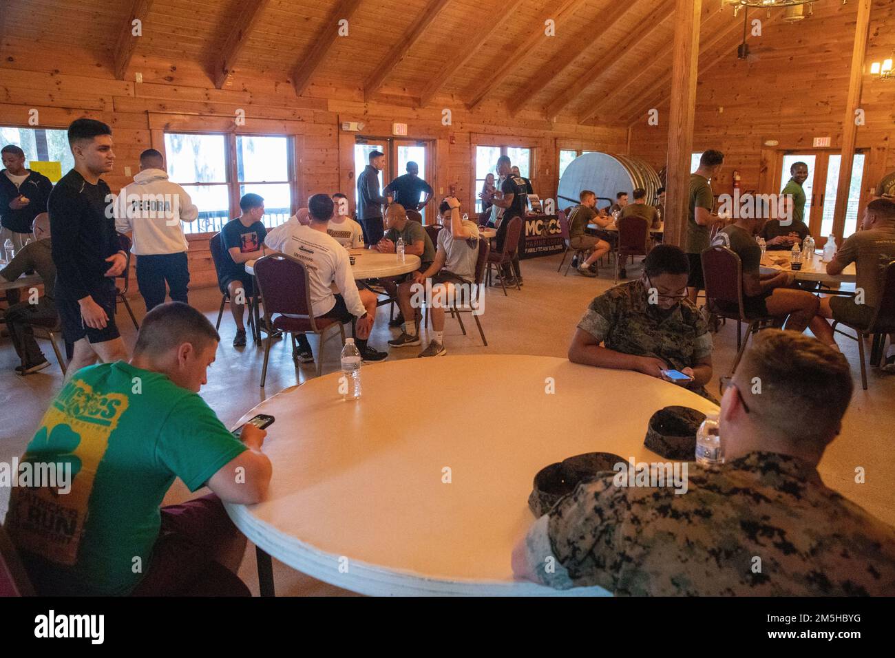 USA Marines und Matrosen mit der Marine Aircraft Group 31 und Headquarters and Headquarters Squadron, Marine Corps Air Station (MCAS) Beaufort, essen und unterhalten sich nach dem St. Patrick's Day Amazing Race in MCAS Beaufort, South Carolina, 17. März 2022. Nach dem Rennen endete die Veranstaltung mit einem Frühstück und einer Preisverleihung. Stockfoto