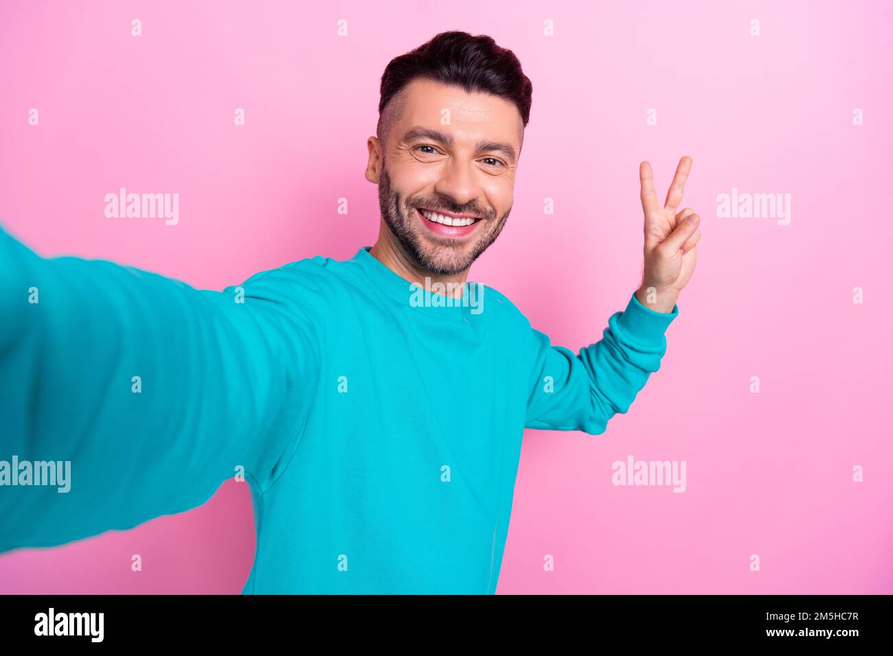 Selfie Nahaufnahme Porträtfoto von attraktivem jungen, gutaussehenden Mann brauner Bart Make Shot Show V-Zeichen Frieden isoliert auf pinkfarbenem Hintergrund Stockfoto