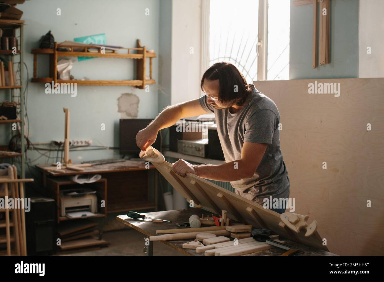 Ein erwachsener, männlicher Zimmermann, der mit Werkzeugen in seiner Holzwerkstatt arbeitet - Stockfoto Stockfoto