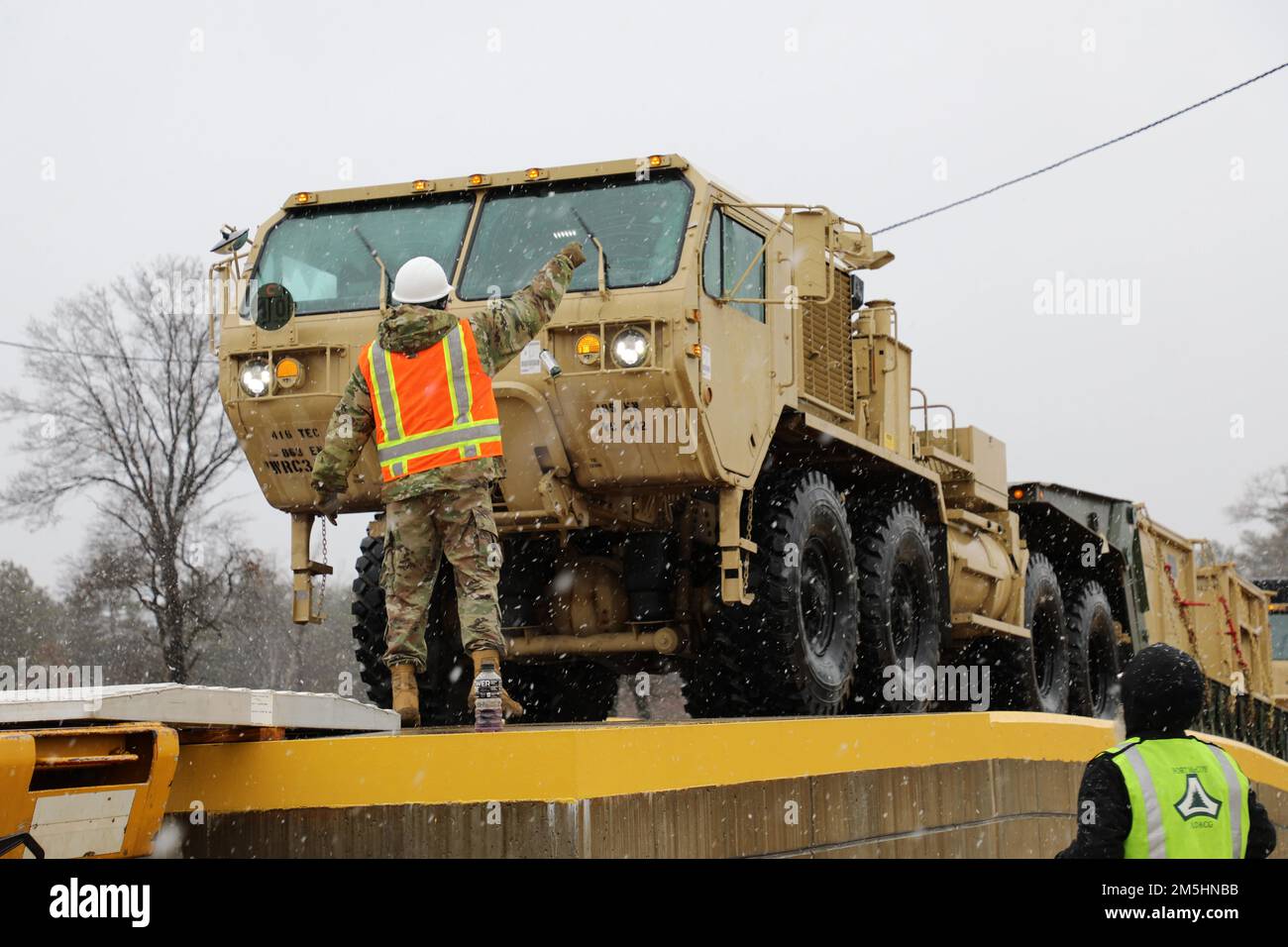 Sgt. Berkeley Taylor von der 485. Engineer Company aus Arlington Heights, Ill. Fungiert als Bodenführer während der Verladung von Schienen am 18. März 2022 in Fort McCoy, Wis. die 485. verladen Fahrzeuge in Vorbereitung auf ihren bevorstehenden Einsatz. Stockfoto