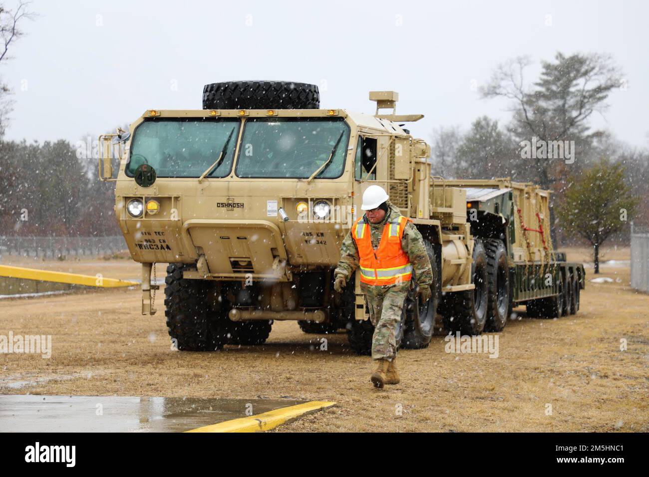 Sgt. Berkeley Taylor von der 485. Engineer Company aus Arlington Heights, Ill. Fungiert als Bodenführer während der Verladung von Schienen am 18. März 2022 in Fort McCoy, Wis. die 485. verladen Fahrzeuge in Vorbereitung auf ihren bevorstehenden Einsatz. Stockfoto