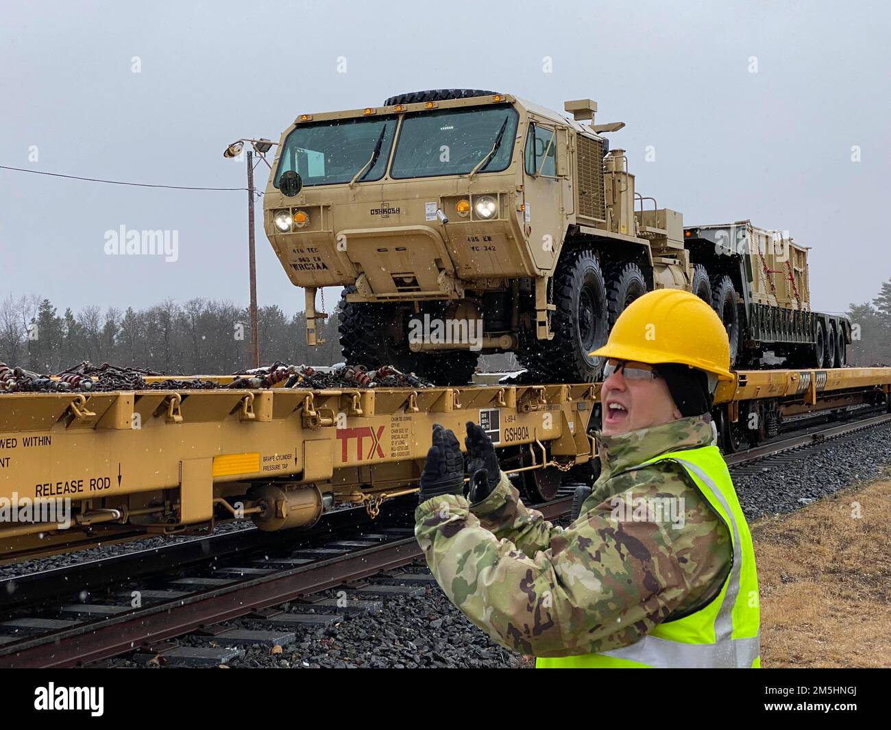 Staff Sgt. Joseph Korotasz, Unit Movement Officer von der 485. Engineer Company aus Arlington Heights, Illinois, leitet den Betrieb bei der Beladung der Eisenbahn am 18. März 2022 in Fort McCoy, Wisconsin. Der 485. beladte Fahrzeuge in Vorbereitung auf ihre bevorstehende Bereitstellung. Stockfoto