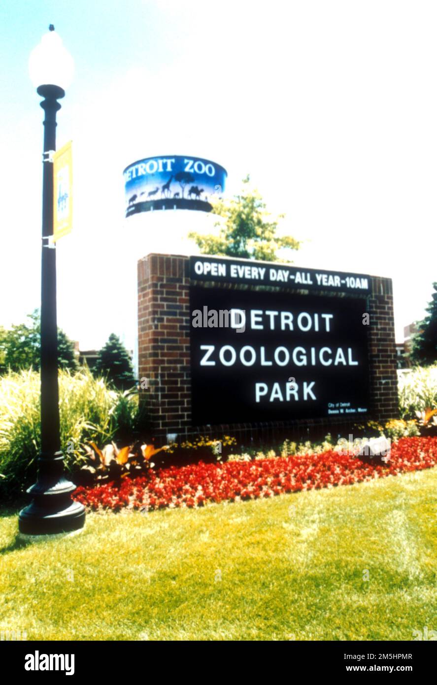 Woodward Avenue (M-1) - Automotive Heritage Trail - Eingang Detroit Zoo. Rote Blumen säumen das Schild, das Besucher im Zoo von Detroit willkommen heißt. Standort: Michigan (42,475° N 83,156° W) Stockfoto