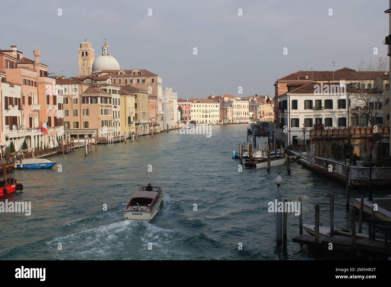 Ein Boot auf dem Canale Grande unter dem Sonnenuntergang, das die Häuser Venedig, Italien, beleuchtet Stockfoto