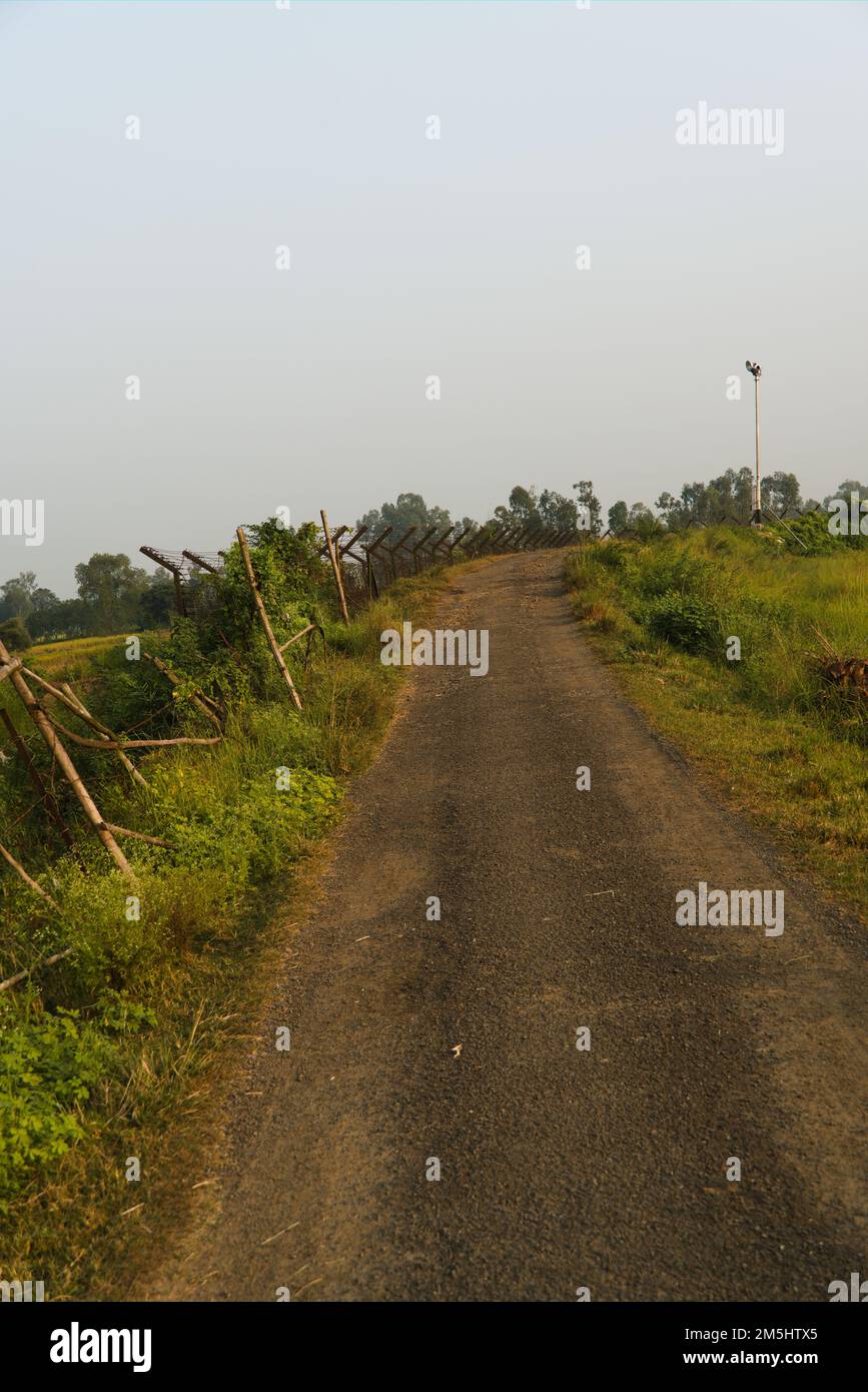 13.11.2022 . Radhikapur, Westbengalen, Indien. Schwarze Asphaltstraße an der internationalen Grenze zwischen Indien und Bangladesch. Stockfoto