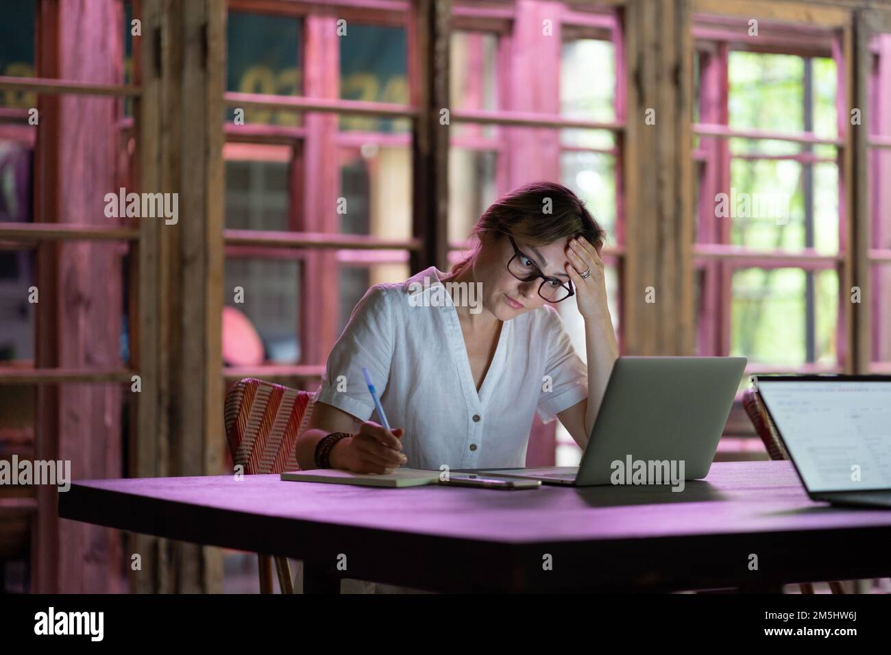 Konzentrierte kaukasische Studentin, die sich im Coworking Space einen Webinar-Videokurs auf dem Laptop ansieht Stockfoto
