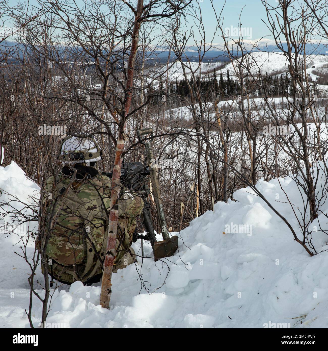 Staff Sgt. Jeff Early, A Paratrooper from Apache Company, 1. Bataillon, 501. Parachute Infanterie Regiment, 4. Infanterie Brigade Combat Team (Airborne), 25. Infanterie Division, ‚Spartan Brigade,‘ mans der MK 19 Granatenwerfer an einem Beobachtungspunkt während des Joint Pacific Multinational Readiness Center 22-02, 18. März 2022. JPMRC 22-02, ausgeführt in Alaska mit seinen erstklassigen Trainingseinrichtungen und der rauen arktischen Umgebung, baut Soldaten und Anführer zu einem Team aus erfahrenen, harten, aufmerksamen und anpassungsfähigen Kriegern zusammen, die überall kämpfen und gewinnen können. Stockfoto