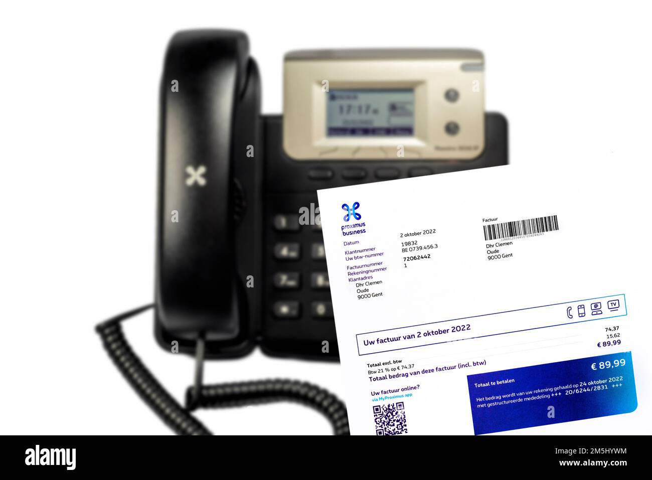 Rechnung von Proximus, Anbieter digitaler Dienste und Kommunikation in Belgien, vor schwarzem IP-Tischtelefon, Nahaufnahme auf weißem Hintergrund Stockfoto