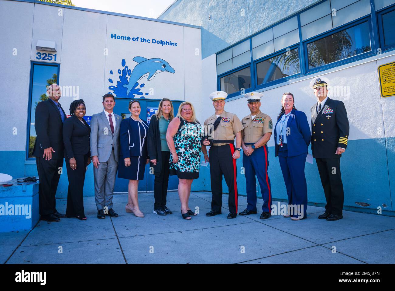 Anführer des Marine Corps Recruit Depot (MCRD) San Diego machen ein Gruppenfoto mit den USA Navy Sailors and the Staff of Dewey Elementary School in San Diego, 18. März 2022. Schulen, die am Purple Star-Programm teilnehmen, unterstützen ihre Schüler, die nicht Teil von Militärfamilien sind. Stockfoto