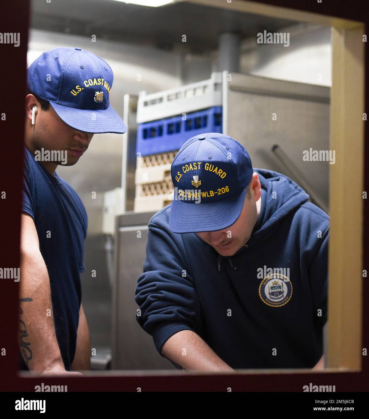 USA Küstenwache Petty Officer 1. Klasse Jason Martinez, ein kulinarischer Spezialist an Bord der Küstenwache Cutter Spar, weist Seemann Andres Garcia in die Schülerei ein, während er im Atlantischen Ozean unterwegs ist, am 18. März 2022. Spar und ihre Crew reisen nach Duluth, Minn. nach einer einjährigen Wartungszeit in Baltimore. Stockfoto