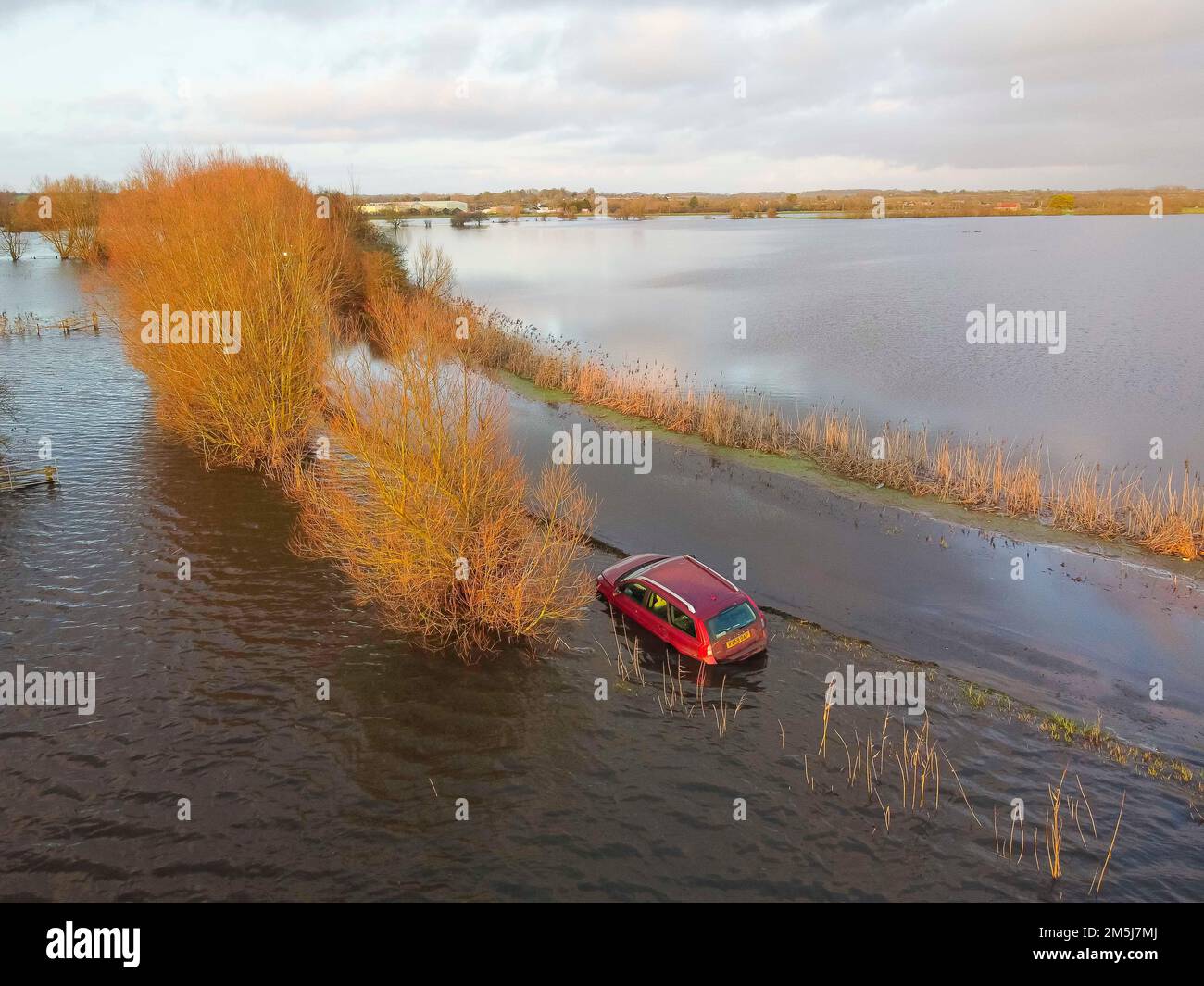 Muchelney Somerset, Großbritannien. 29. Dezember 2022 Wetter in Großbritannien. Ein Auto steckt auf der Straße zwischen Muchelney und Langport in Somerset in Überschwemmungen fest, nachdem die Flussparrett ihre Ufer geplatzt und die Felder und die Straße nach starkem Regen überflutet hat. Bildnachweis: Graham Hunt/Alamy Live News Stockfoto