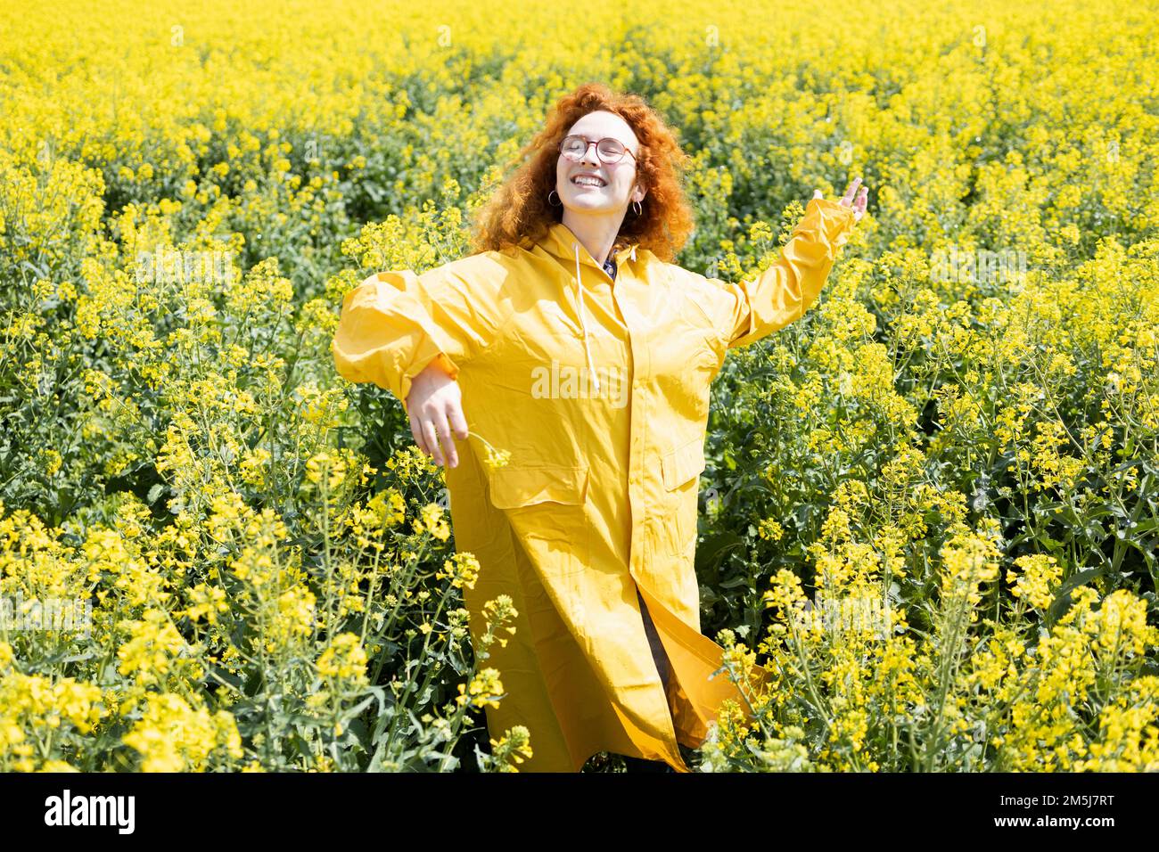 Eine Frau, die auf einem wunderschönen gelben Feld tanzt Stockfoto