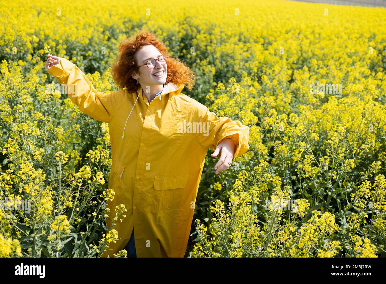 Eine Frau, die auf einem Blumenfeld tanzt und singt Stockfoto