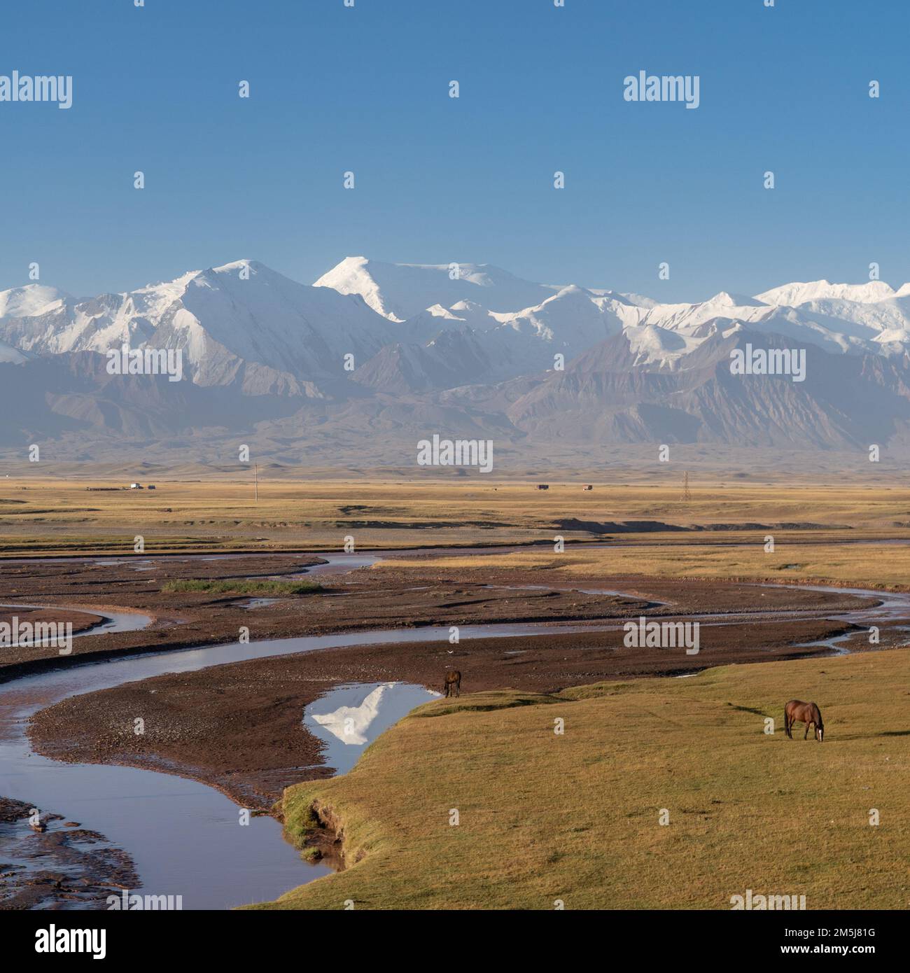 Landschaftsblick am Vormittag auf die spektakulären schneebedeckten Berge Trans-Alai oder Trans-Alay mit Reflexion auf dem Fluss Kirzylsu im Süden Kirgisistans Stockfoto