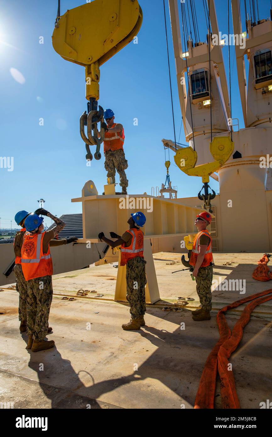 USA Navy Sailers mit Navy Cargo Handling Bataillon 1 und Navy Cargo Handling Bataillon 5, bereiten einen Doppelliftkran vor, um einen Equalizer an Bord der USNS 1. LT. Jack Lummus (T-AK 3011) zur Unterstützung der 3. Marine Logistics Group während der Übung Atlantic Dragon auf Marine Corps Support Facility Blount Island anzubringen. Florida, Usa, 18. März 2022. Atlantic Dragon ist eine Übung zur Kraftgenerierung, bei der das Kampflogistikrevier 37 als Ankunftsgruppe eingesetzt wird, um taktische logistische Unterstützung für die III Marine Expeditionary Force zu leisten. Die Übung besteht aus einem experimentellen maritimen Pre Stockfoto