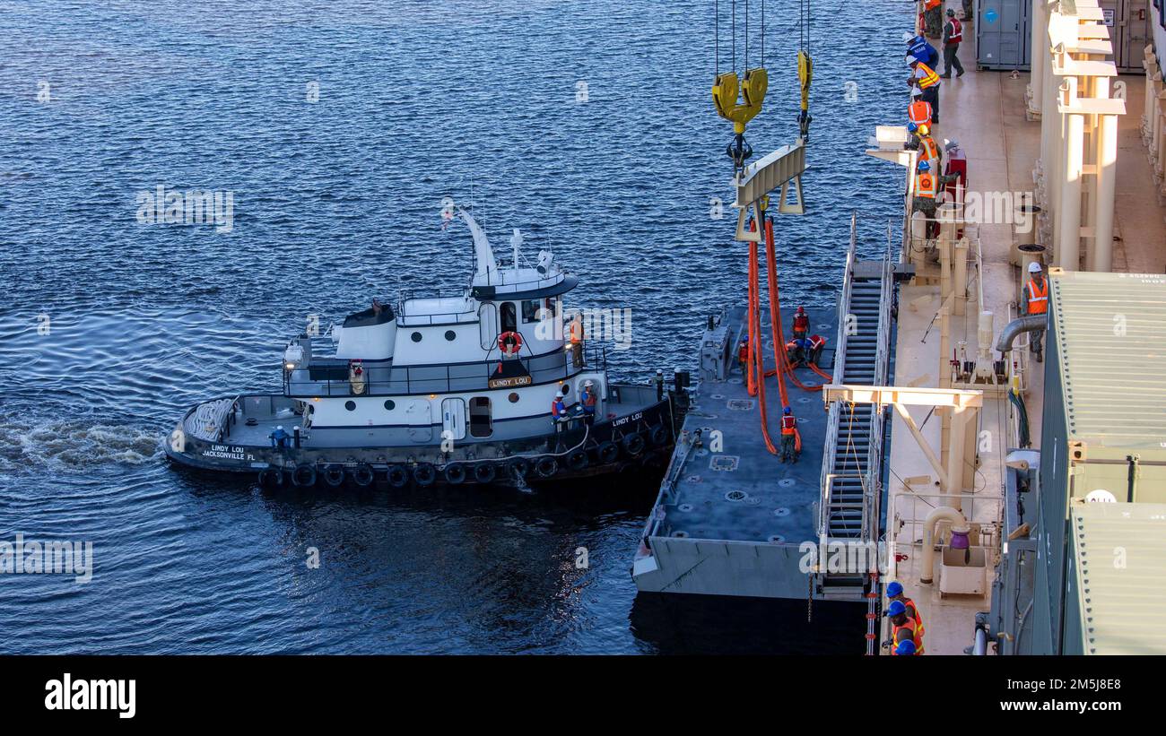 USA Navy-Matrosen mit Navy Cargo Handling Battalion 1 und Navy Cargo Handling Battalion 5 führen mit dem Strandmodul des verbesserten Navy Lighterage System an Bord der USNS 1. LT. Jack Lummus (T-AK 3011) eine seitliche Entladung am Pier durch. Zur Unterstützung von 3. Marine Logistics Group während der Übung Atlantic Dragon on Marine Corps Support Facility Blount Island, Florida, USA, 18. März 2022. Das INLS wird während einer vorgelagerten Seekraft bei der Abladung von Bach- oder Pier-Seiten verwendet, um eine Transportart für Fracht zwischen strategischen Seeschiffen oder an Land bereitzustellen. Atlantic Dragon ist eine Generatio der Macht Stockfoto