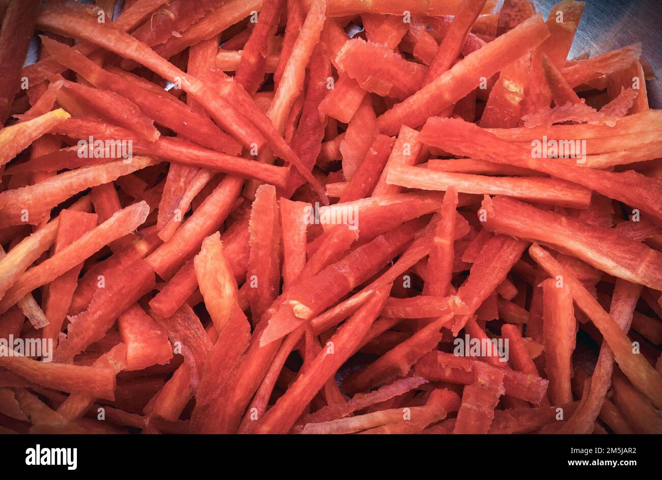 Geriebene Karotten in kleinen Stücken, ein Haufen frischer roter geriebener Karotten, eine Schnittkollage und geriebene Karotten auf Holz Stockfoto