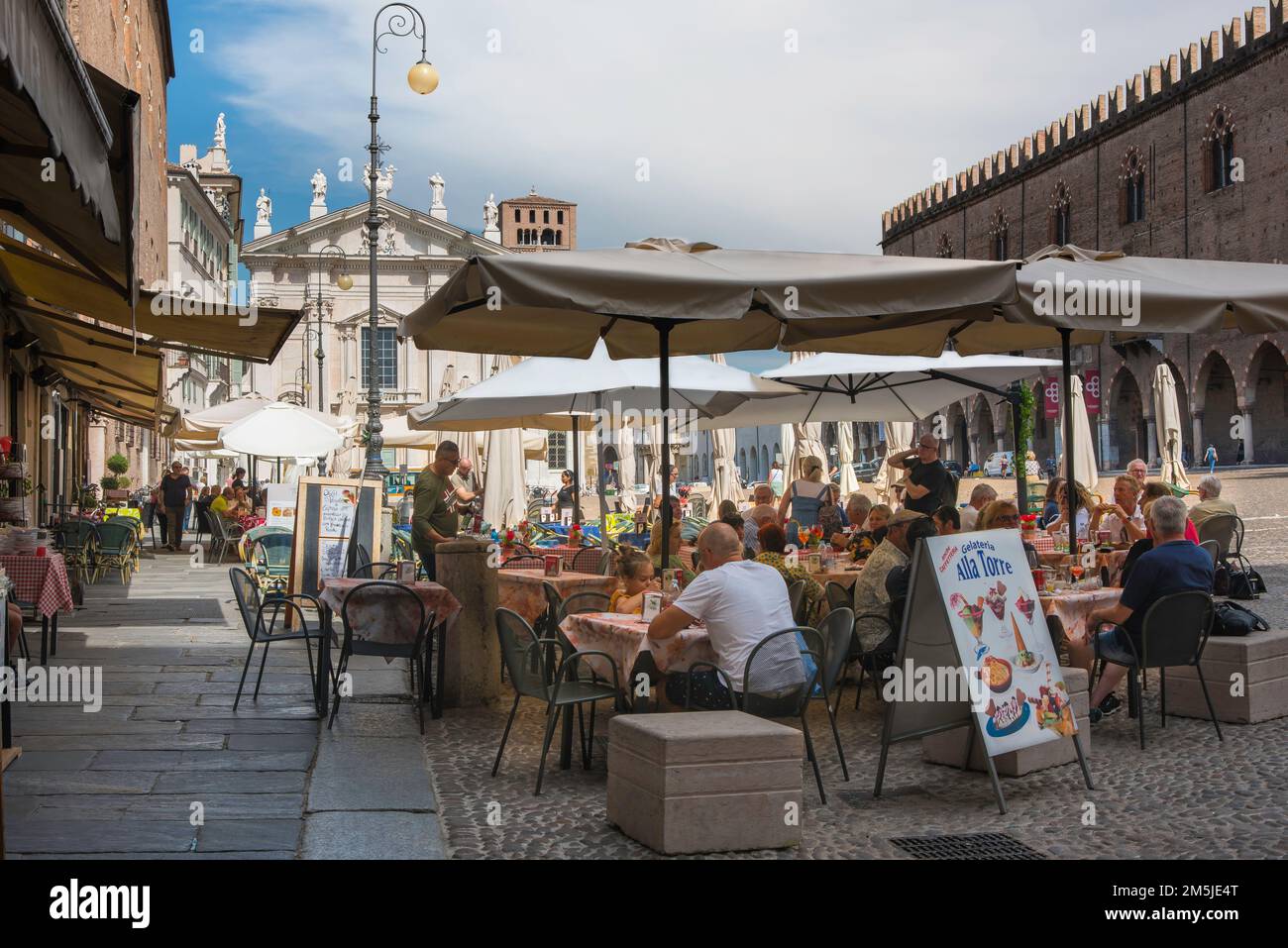 Italiener Straßencafé, Blick im Sommer auf die Menschen, die an Cafetstischen auf der Piazza Sordello sitzen, einem malerischen Renaissance-Platz in Mantua, Lombardei, Italien Stockfoto