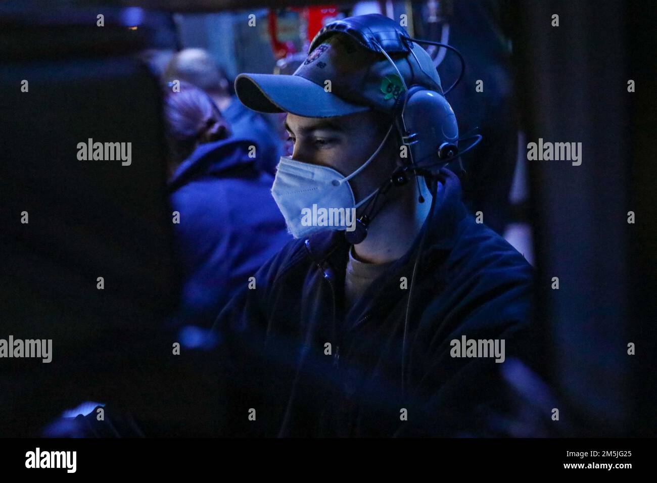 220319-N-HK187-1007 OSTSEE (19. März 2022) – Feuerwehrmann der Klasse 1. (Aegis) Mason Kraus, der der Arleigh-Burke-Klasse-Guided-Missile Destroyer USS the Sullivans (DDG 68) zugeteilt wurde, steht im Kampfinformationszentrum des Schiffes am 19. März 2022 Wache. Die Sullivans werden in das europäische Operationstheater entsandt und nehmen an einer Reihe von maritimen Aktivitäten zur Unterstützung der USA Teil Sechste Flotte und NATO-Alliierten. Stockfoto