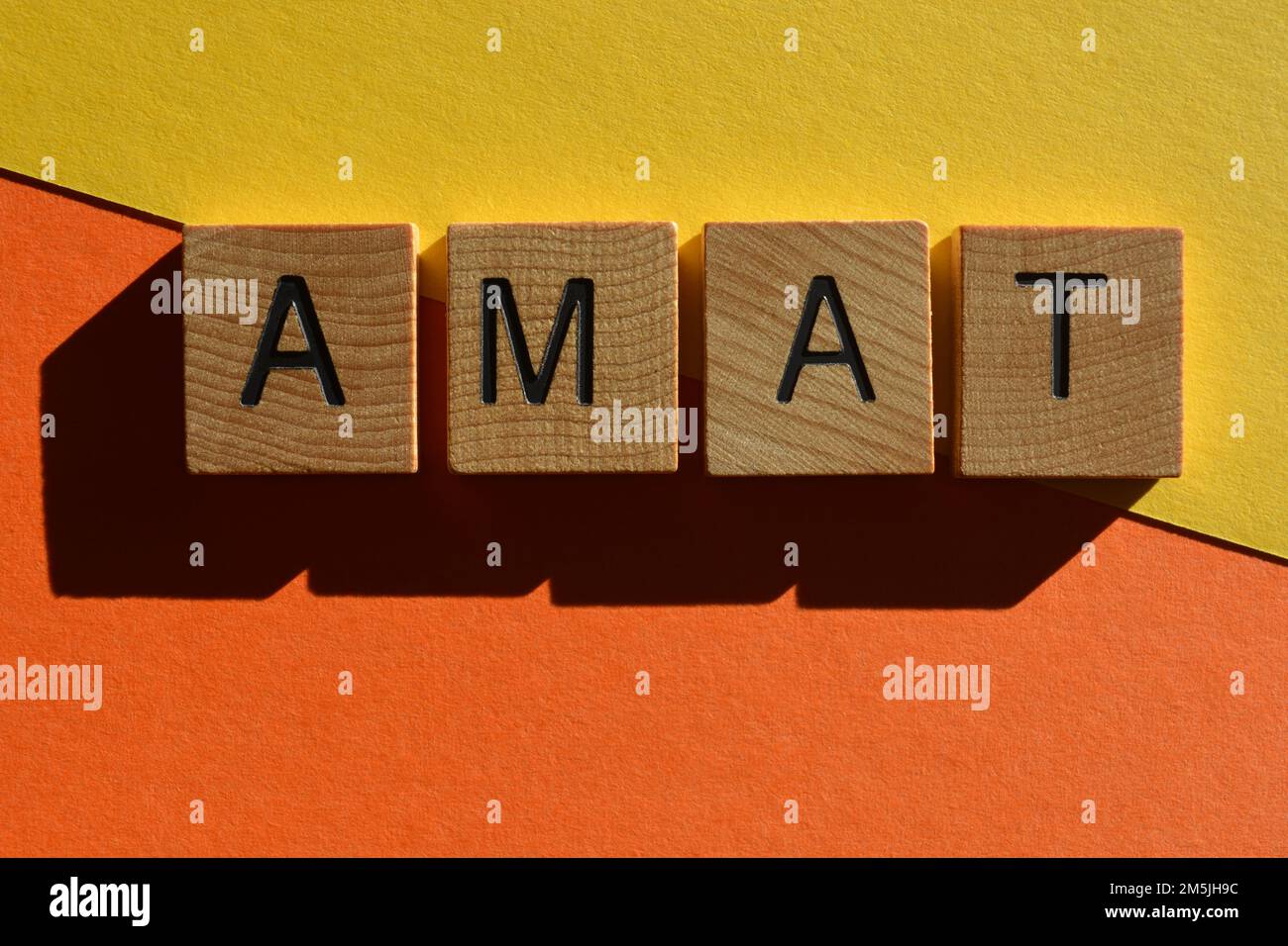 AMAT, Akronym für All Mouth and Hosen, in hölzernen Buchstaben isoliert auf farbenfrohem Hintergrund Stockfoto