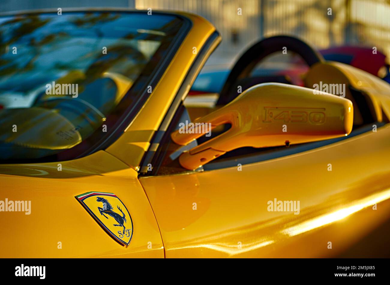 Gelber Ferrari F430 Spider oder Cabrio mit dem Ferrari-Emblem oder Logo auf der Fahrerseite. Stockfoto