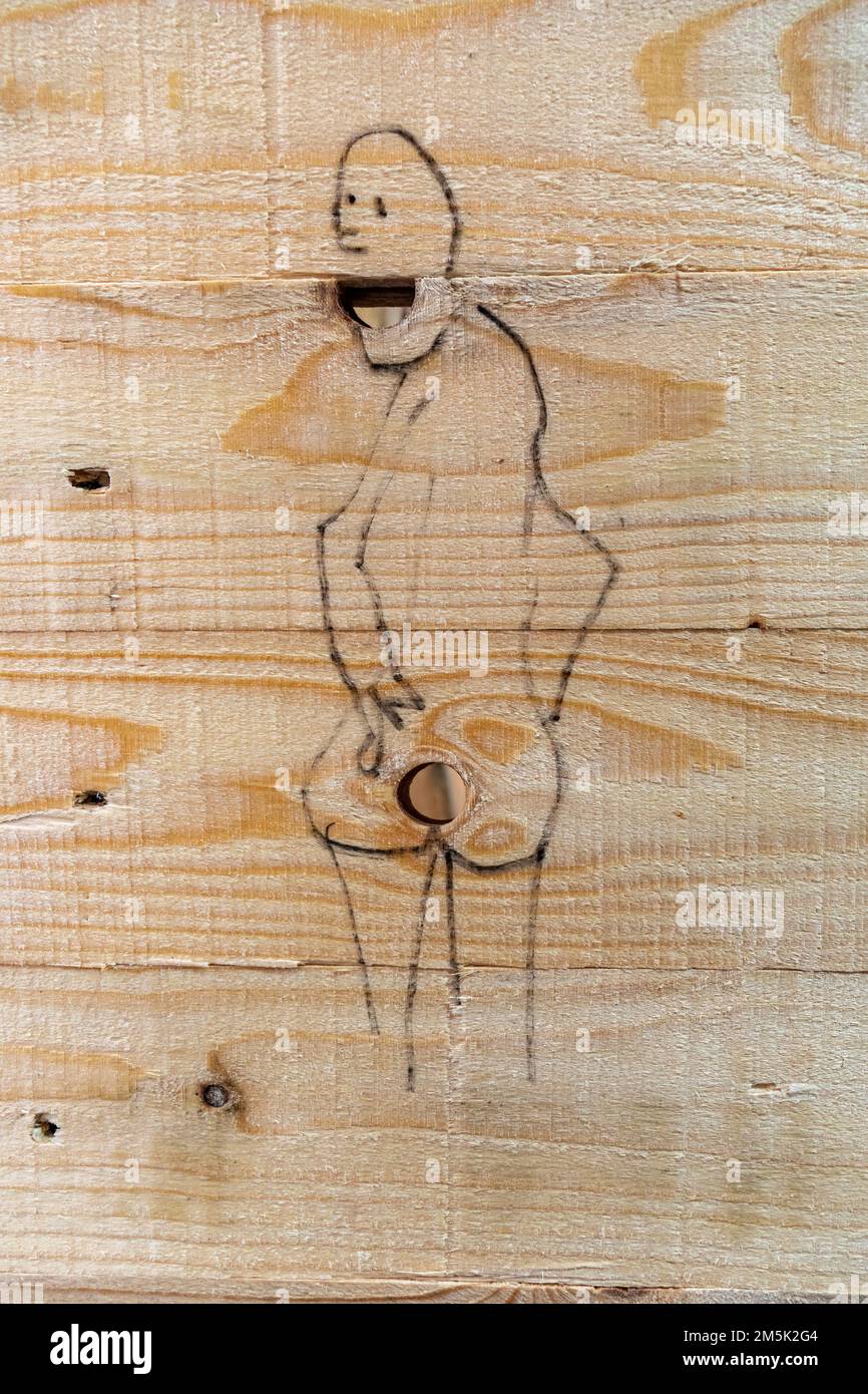 Lustige Zeichnung mit Knotholen an einem Baustellenzaun Stockfoto