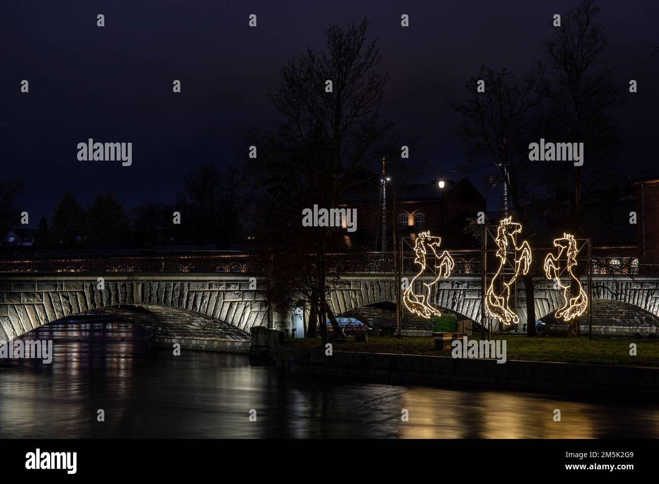 Hepat laiduntaa Lichtinstallation auf Konsulinsaari mit beleuchteter Satakunnansilta-Steinbrücke im Hintergrund in Tampere, Finnland Stockfoto