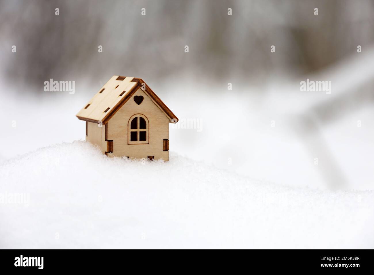 Holzhaus Modell im Schnee auf Winterwald Hintergrund. Konzept von Landhaus, Immobilien in ökologisch sauberer Umgebung Stockfoto