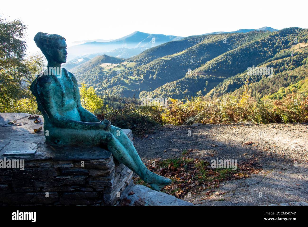 Der kleine Pilger. Statue einer jungen Frau, die mit einem Rucksack am Bergpass von O Cebreiro in Galicien, Nordspanien, entlang der historischen Pilgerroute des Camino de Santiago sitzt Stockfoto
