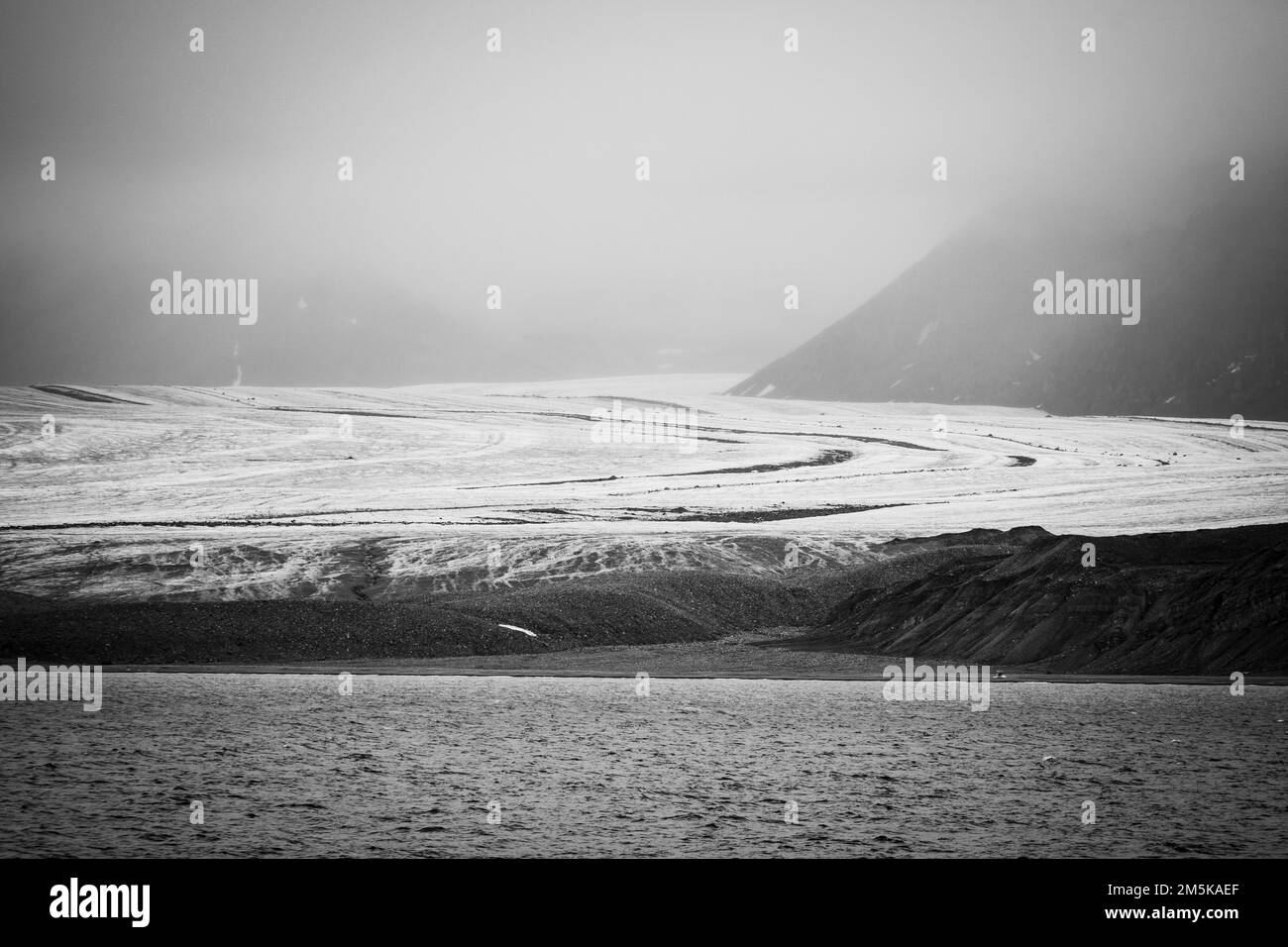 Gletscher, der von den Bergen von Bylot Island in Nunavut, Kanada, auf das Meer trifft. Stockfoto