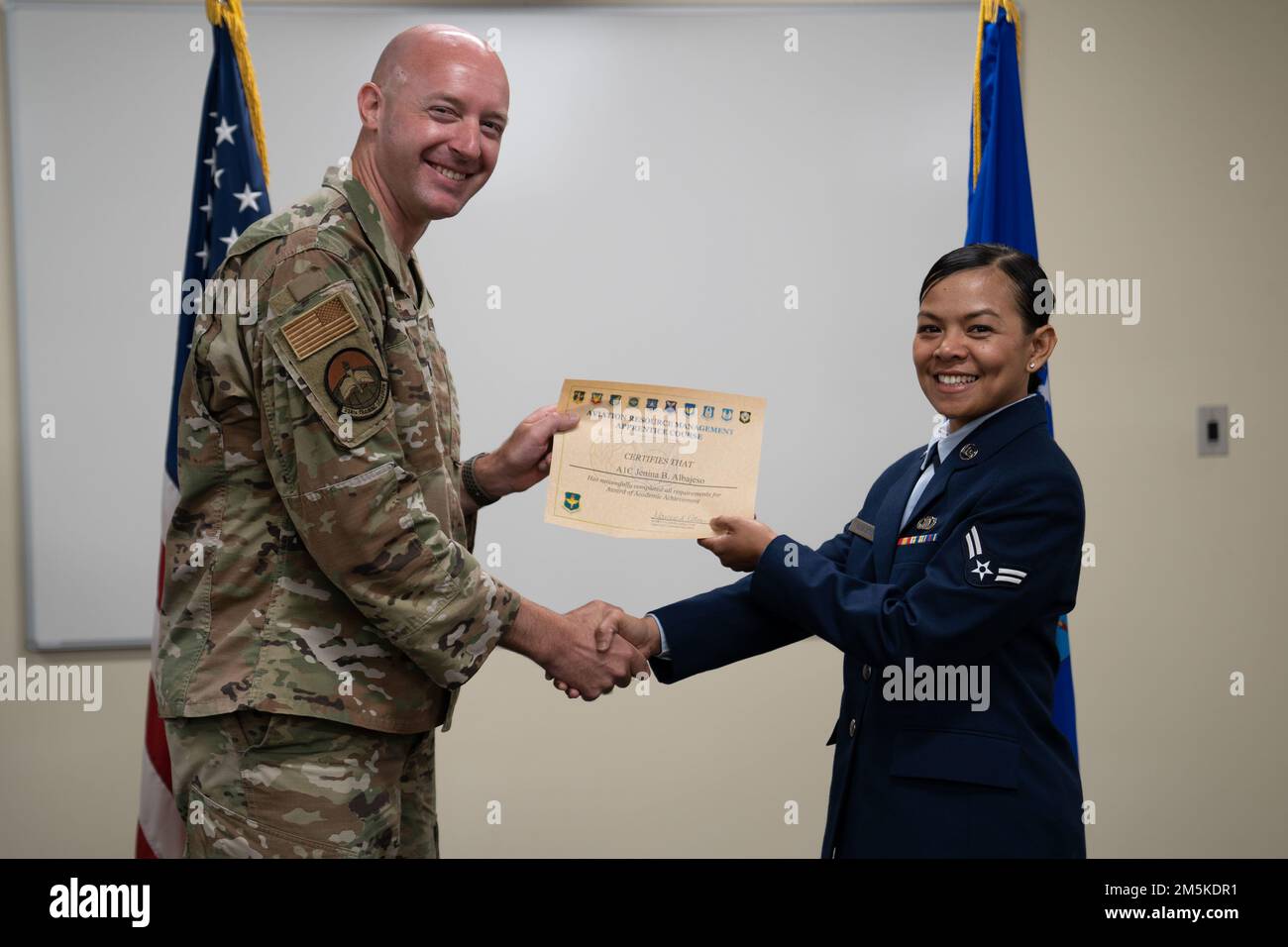 USA Air Force Airman 1. Class Jenina Albajeso, Student der 334. Training Squadron, erhält ein Zertifikat von LT. Oberstleutnant Matthew Hopkins, 334. TRS Commander, während einer Abschlussfeier in Cody Hall auf der Keesler Air Force Base, Mississippi, 22. März 2022. Albajeso erhielt bei allen vier Blocktests im Lehrkurs Aviation Resource Management Systems ein perfektes Ergebnis. Stockfoto