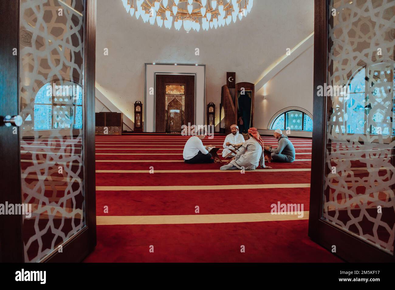 Eine Gruppe von Muslimen, die das heilige Buch des Korans während des muslimischen Feiertags von Ramadan in einer modernen Moschee las Stockfoto