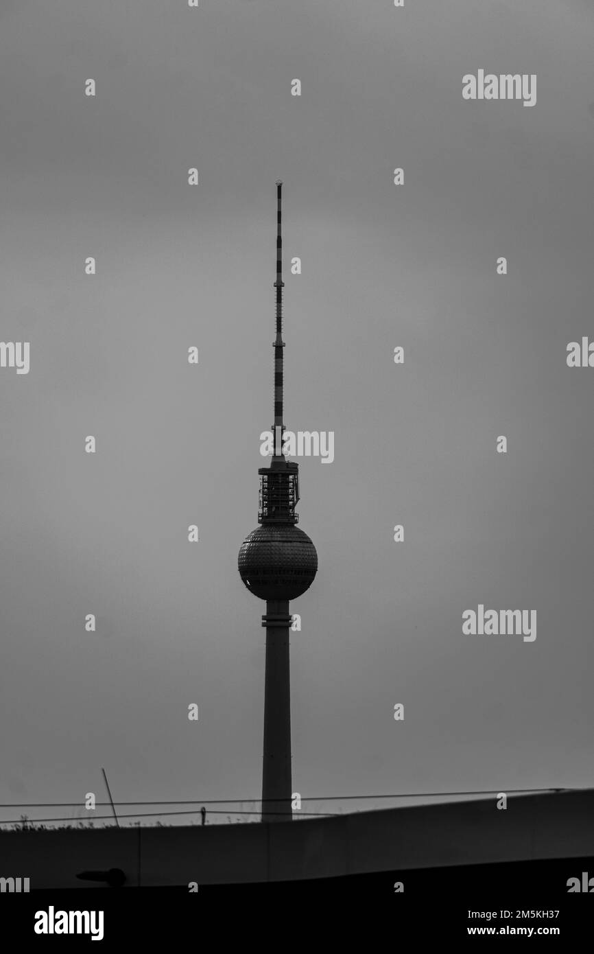 Ein vertikales Bild des Fernsehturms in Berlin unter dem bewölkten Himmel Stockfoto