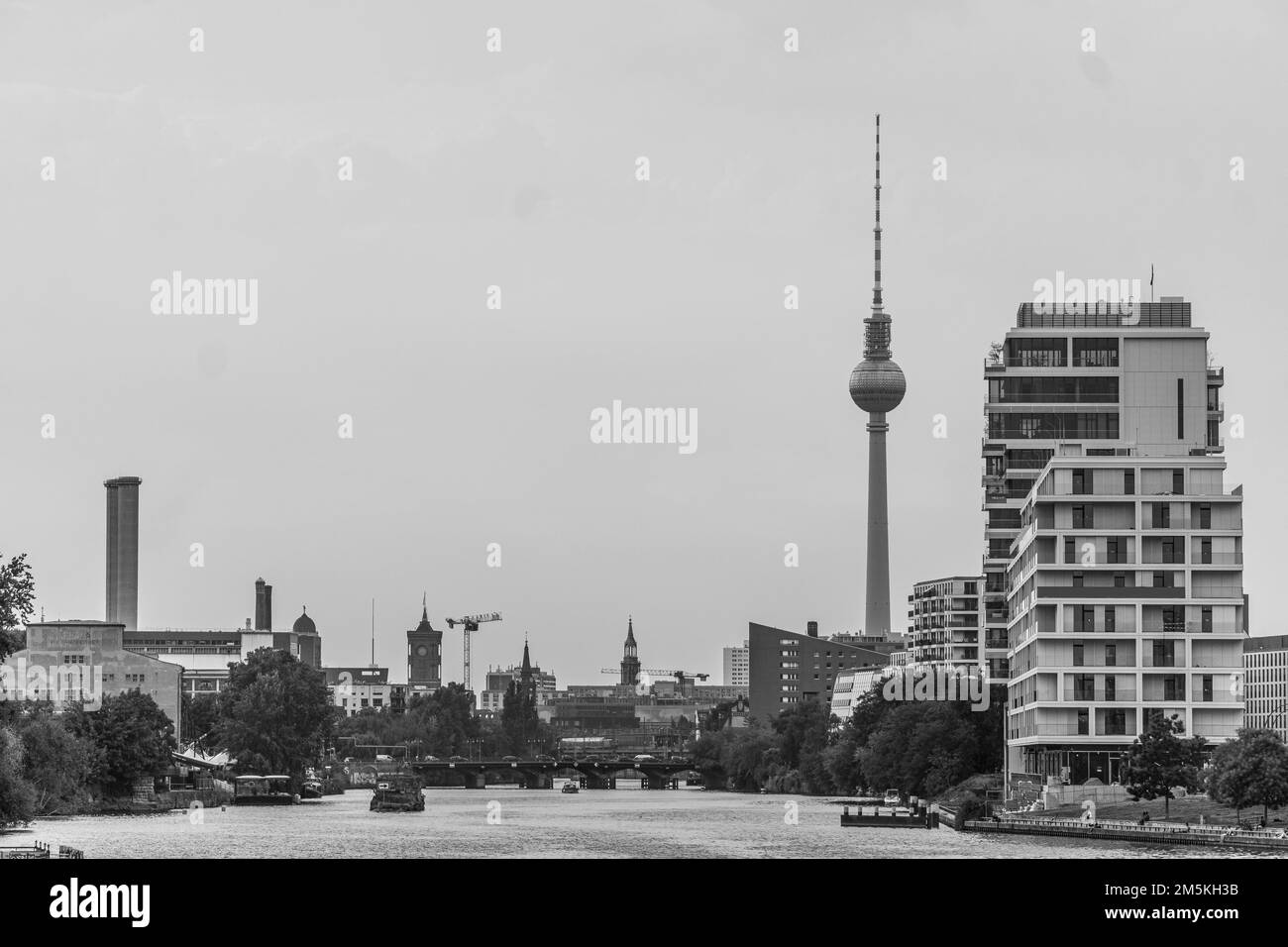 Ein Landschaftsbild des Baus über den Fluss in Berlin, Deutschland, unter dem bewölkten Himmel Stockfoto